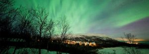 Northern Lights over snowy landscape in Abisko National Park Sweden
