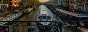 Amsterdam canal with boats and historic houses Netherlands