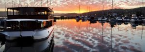 Luxury houseboat at sunset on the Knysna Lagoon with colorful sky reflections and calm waters