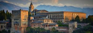 Alhambra Palace in Granada Spain with historic Moorish architecture and Sierra Nevada mountains at sunset