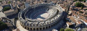 Aerial view of the ancient Roman amphitheater Arles Amphitheatre surrounded by historic buildings in southern France