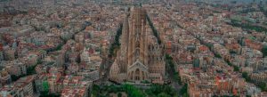 Aerial view of Sagrada Família surrounded by the dense cityscape of Barcelona at sunset