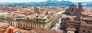 Panoramic aerial view of Bologna featuring historic rooftops, Bologna Cathedral and surrounding hills