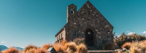 Stone Church of the Good Shepherd in Lake Tekapo, New Zealand with scenic mountains and clear blue sky