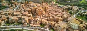 Aerial view of Città della Pieve with terracotta rooftops, medieval towers, and winding streets in a historic hill town.