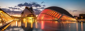 Futuristic City of Arts and Sciences in Valencia Spain at sunset with illuminated Hemisfèric and Palau de les Arts reflected in water