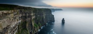 Cliffs of Moher towering above the Atlantic Ocean at sunset with rugged rock formations and sea stack