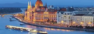 Hungarian Parliament Building illuminated at dusk along the Danube River in Budapest