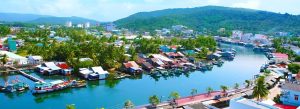Scenic view of the Duong Dong River flowing through Duong Dong Town with fishing boats, riverside homes, and lush green hills