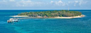 Aerial view of Green Island with jetty, white sandy beaches, and turquoise waters in the Great Barrier Reef near Cairns, Australia