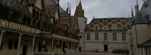 Hospices de Beaune courtyard with colorful geometric tiled roofs and historic medieval architecture