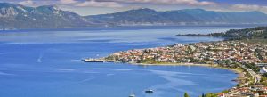 Panoramic view of Kamena Vourla on the Malian Gulf, featuring a seaside town, calm blue waters, and mountainous backdrop