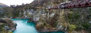 Bungee jumping at Kawarau Gorge Suspension Bridge over turquoise Kawarau River in Queenstown New Zealand