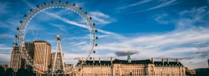 View of the London Eye overlooking the River Thames and County Hall under a blue sky in central London