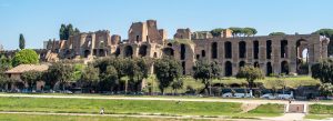 Palatine Hill ruins overlooking green parkland and ancient arches under a clear blue sky