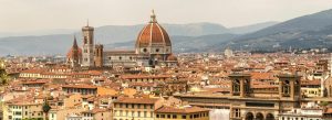 Panoramic view of Florence from Piazzale Michelangelo featuring the iconic dome of Florence Cathedral and historic terracotta rooftops.