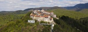 Aerial view of Râșnov Fortress surrounded by lush green Carpathian Mountains in Romania