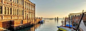Golden hour over Rio del Ponte Piccolo canal with gondolas and historic waterfront buildings on Giudecca in Venice