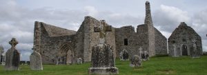 Clonmacnoise Monastic Site with ancient stone ruins and Celtic gravestones under a cloudy sky