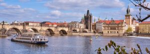 Daytime view of Prague with Charles Bridge, Vltava River, and Old Town towers and historic buildings
