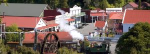 Historic township at Shantytown Heritage Park with steam train, water wheel, and old gold rush buildings