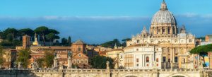 St. Peter’s Basilica with its iconic dome rising above St. Peter’s Square and surrounding historic buildings along the Tiber River