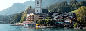 Lakeside village of St. Wolfgang with parish church and alpine hills reflected on Wolfgangsee