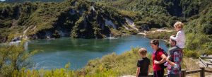 Family enjoying scenic view of geothermal lake at Wai-O-Tapu Thermal Wonderland in Rotorua New Zealand