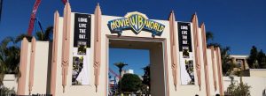 Entrance arch of Warner Bros. Movie World with Batman banners and roller coaster in the background