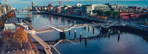 Samuel Beckett Bridge and Ha'penny Bridge over the River Liffey with Dublin city skyline
