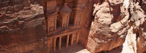 The Treasury monument carved into red rock cliffs in Petra, Jordan