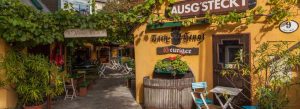 Traditional Alter Bach-Hengl Heuriger wine tavern in Vienna’s Grinzing district with vine-covered courtyard seating.