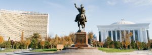 Amir Temur Square in Tashkent, Uzbekistan with equestrian statue surrounded by modern city landmarks and gardens.