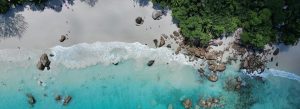 Aerial view of Anse Source d’Argent with turquoise water, white sand beach, and granite boulders in Seychelles.