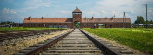 Railway tracks leading to the entrance of Auschwitz-Birkenau Memorial and Museum in Oświęcim, Poland, a historic Holocaust memorial site.