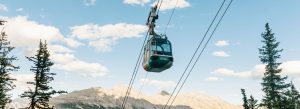 Banff Gondola traveling above pine forests toward the summit of Sulphur Mountain in Banff National Park, Canada.