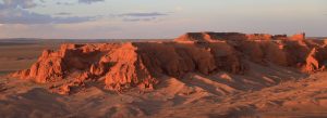 Red sandstone cliffs glowing at sunset in Bayanzag Flaming Cliffs, Gobi Desert, Mongolia