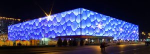 Beijing National Aquatics Center Water Cube glowing blue at night with modern architectural design