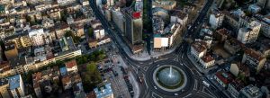 Aerial view of Belgrade city center in Serbia featuring modern streets, buildings, and a large roundabout fountain.