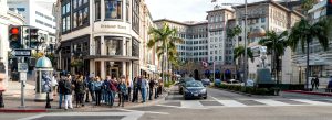 Luxury shopping street with palm trees and designer boutiques in Beverly Hills, Los Angeles, California.