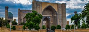Bibi-Khanym Mosque in Samarkand, Uzbekistan with grand Islamic architecture and blue mosaic domes under dramatic skies.