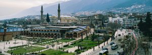 Panoramic view of Bursa Grand Mosque (Ulu Cami) surrounded by the cityscape and mountains in Bursa, Turkey.
