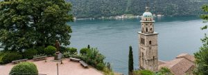 Bell tower and lakeside view near the Cathedral of St. Lawrence in Croatia surrounded by lush greenery and historic architecture.