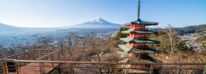 Chureito Pagoda overlooking Fujiyoshida city with Mount Fuji in the background during a clear day in Japan.