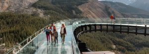 Visitors walking on the Columbia Icefield Skywalk glass platform overlooking mountain valleys in Jasper National Park, Alberta, Canada.