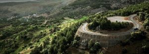 Winding mountain road through the green hills and forests of Tazekka National Park in Morocco.