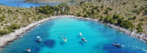 Aerial view of the turquoise bay and anchored boats at the Elaphiti Islands in Croatia surrounded by rocky Mediterranean coastline.
