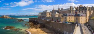 Scenic coastal view of Saint Malo and the Emerald Coast in Brittany, France with turquoise waters and stone walls.