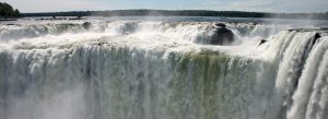 Panoramic view of Garganta del Diablo waterfall at Iguazu Falls in Argentina with massive cascading water and mist rising above the river.