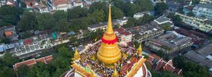Aerial view of Golden Mount Temple in Bangkok, Thailand, featuring the golden stupa surrounded by worshippers and cityscape views.